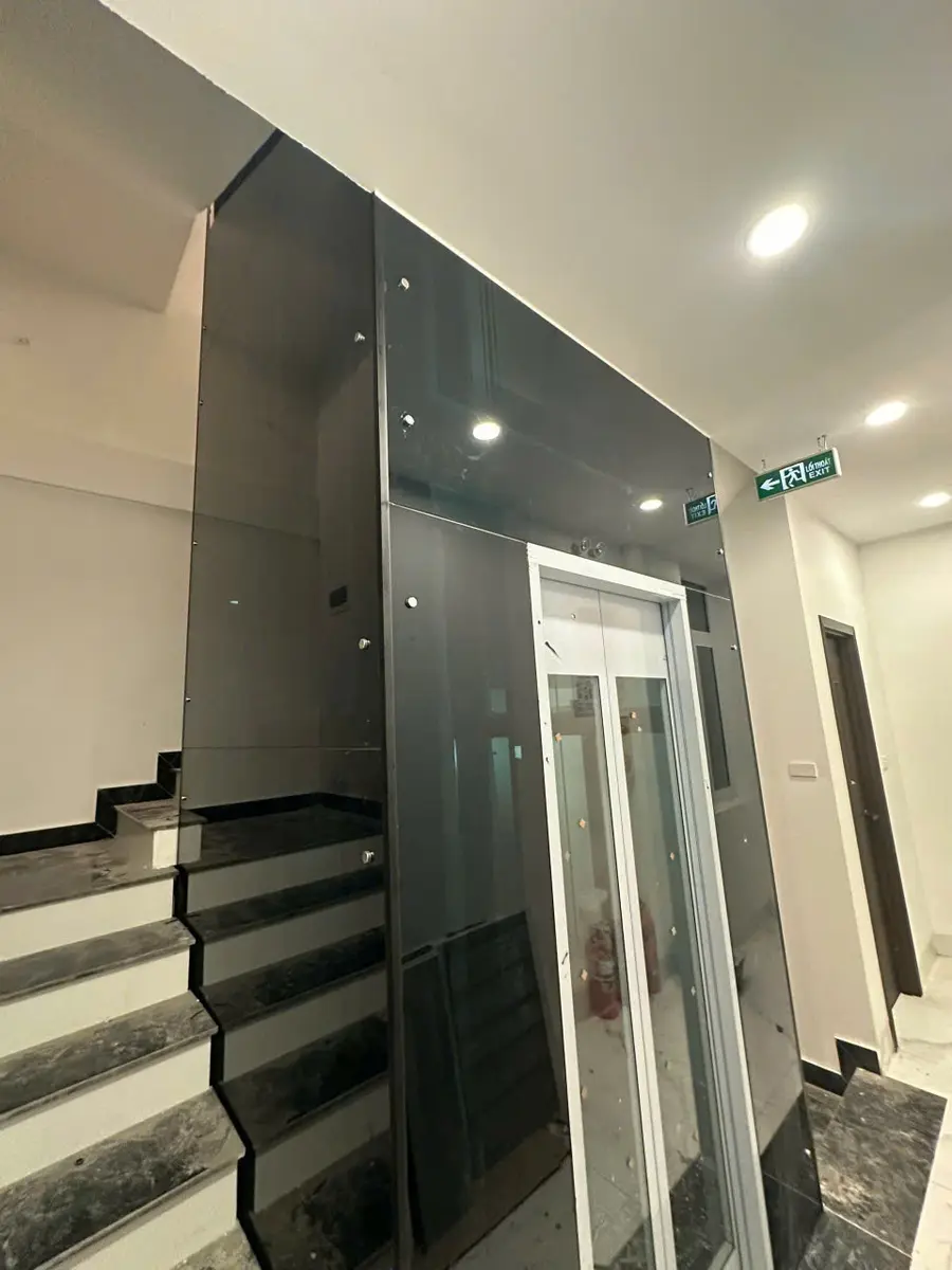 Thang máy cáp kéo giếng kính cạnh cầu thang