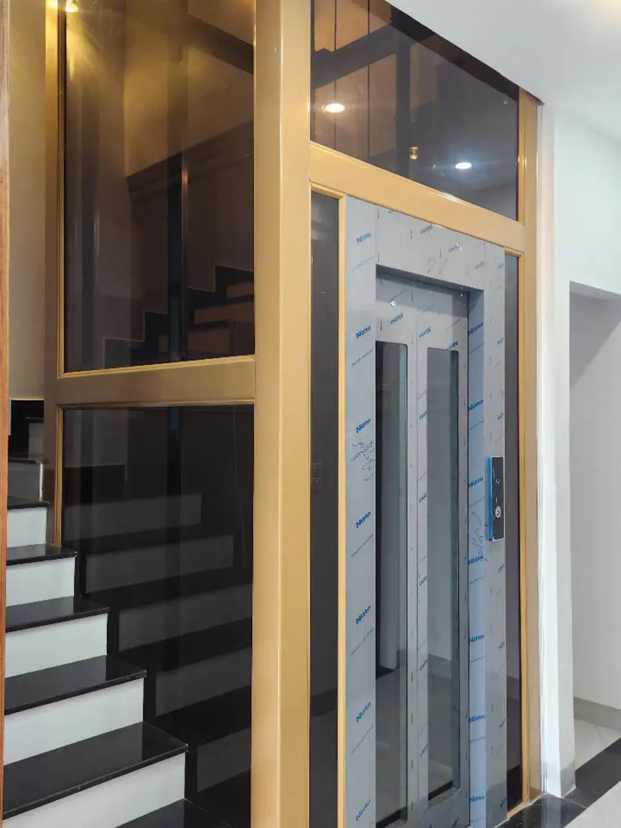 Thang máy cáp kéo giếng kính cạnh cầu thang